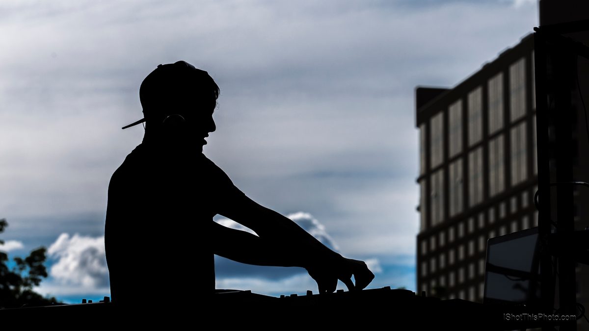 Silhouette of DJ Aaron Jackson at the decks against a cloudy sky at Gravity Electronic Music Festival