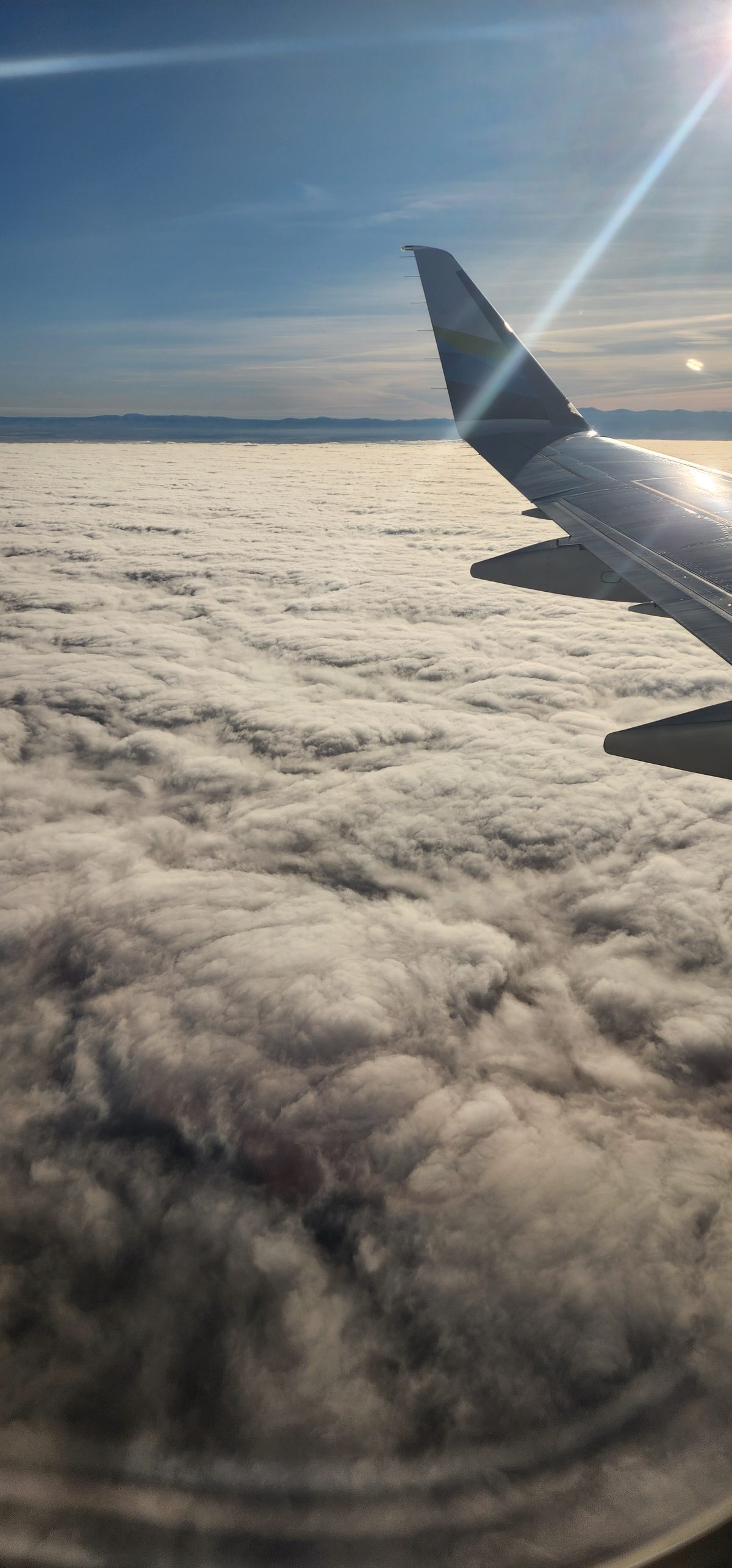 An airplane wing above a sea of clouds