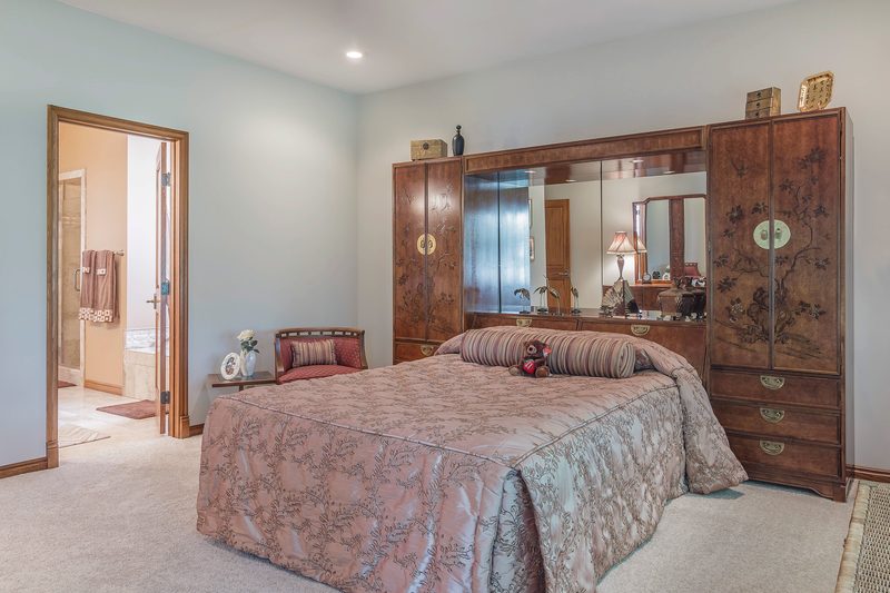 Bedroom with a large wood headboard wall unit with mirrors