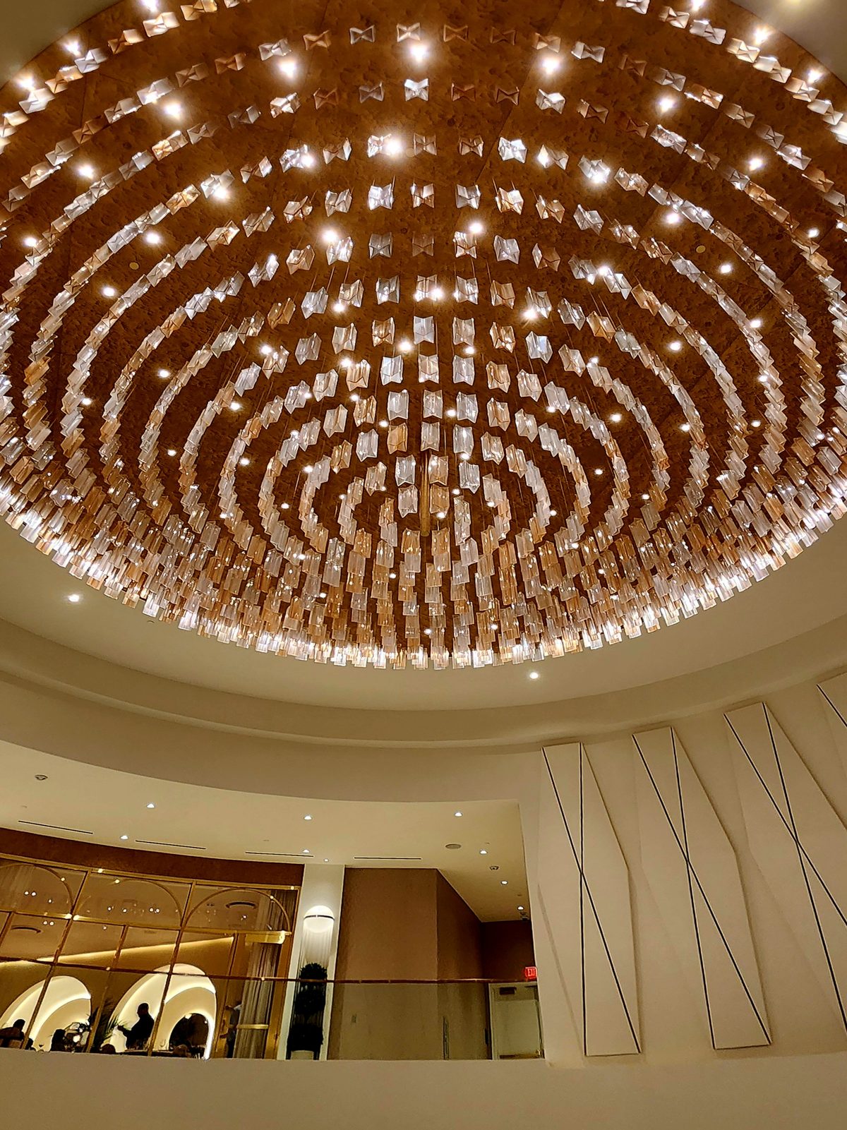 Looking up at a huge circular crystal chandelier