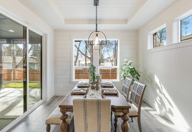 Bright dining room with a long table, a chandelier and sliding glass doors to the yard