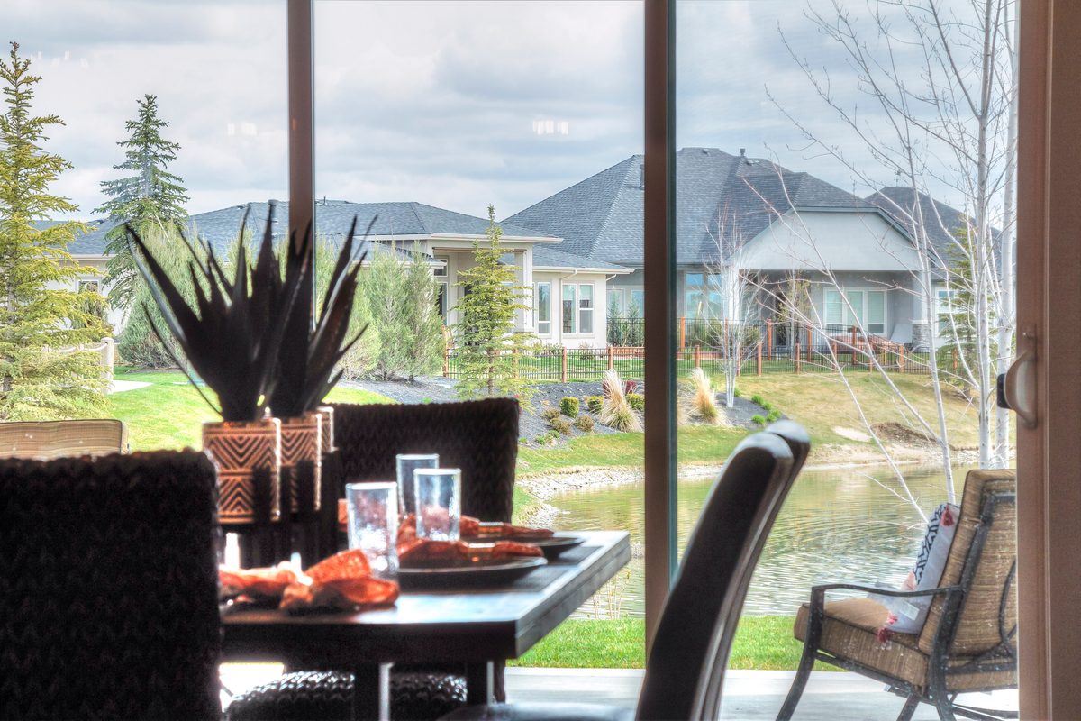 Dining table set for a meal beside sliding doors with a neighborhood and mountain view