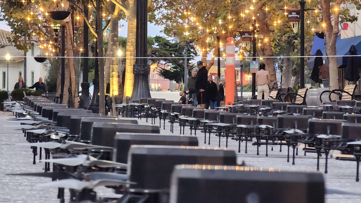 Rows of open drone cases lined up on a plaza at dusk