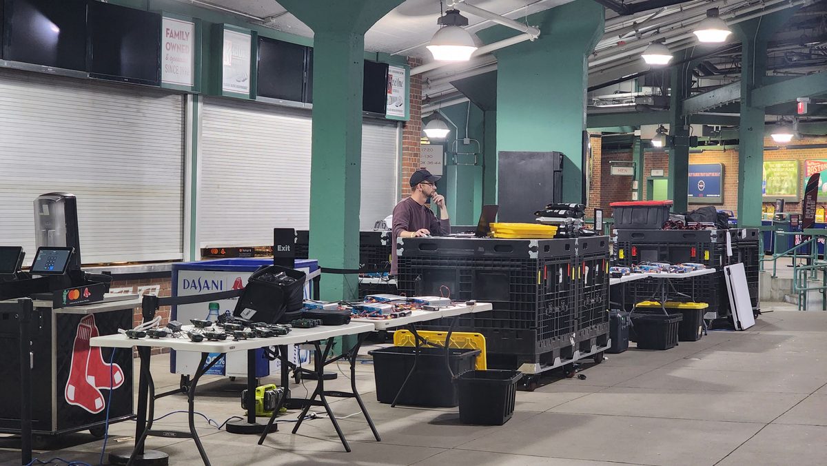 Crew workstations and gear cases set up in a large prep room before a drone show