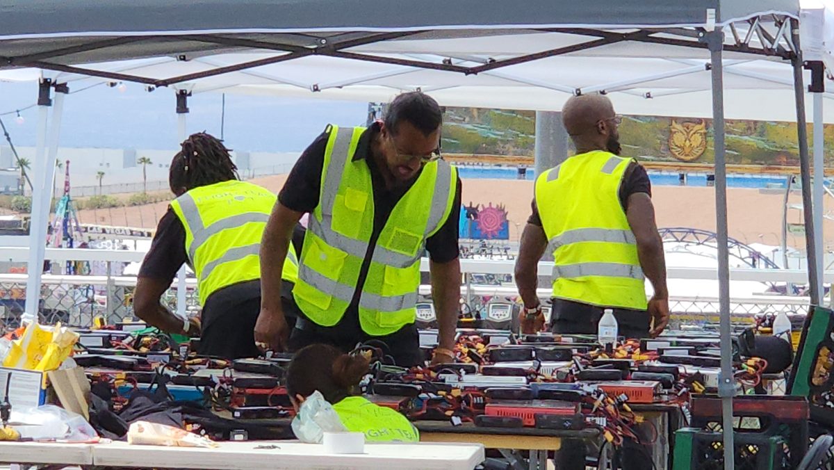 Crew in hi-vis vests working at a pop-up tent over drone cases