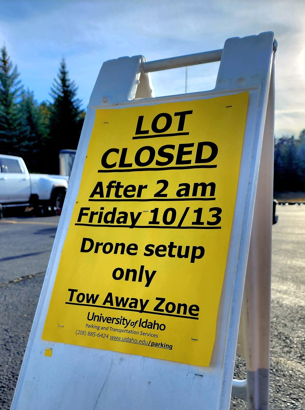 A yellow sandwich-board sign closing a parking lot for drone show setup