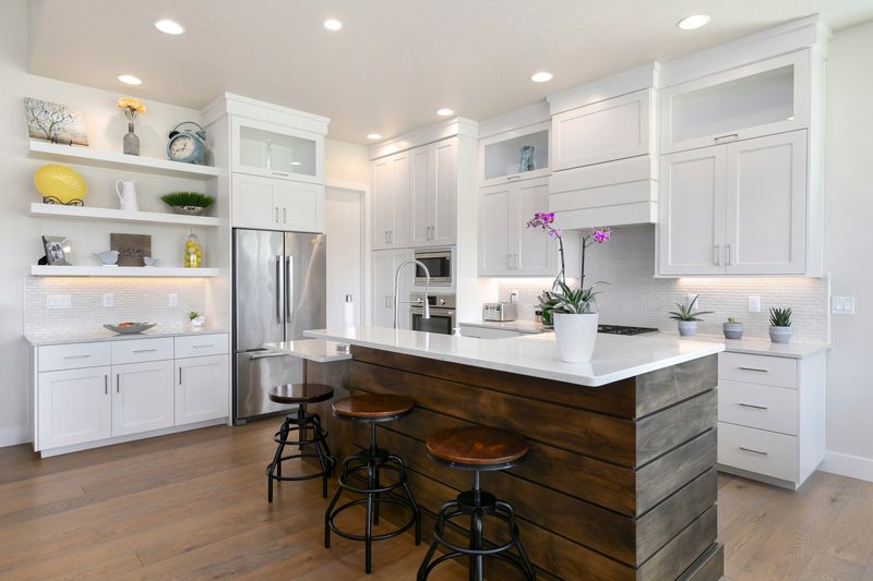 Bright white farmhouse kitchen with open shelving and a reclaimed-wood island with stools