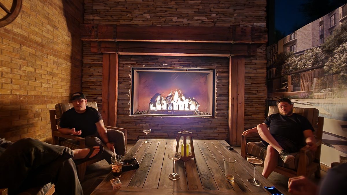 Friends relaxing on leather couches in front of a big lodge fireplace