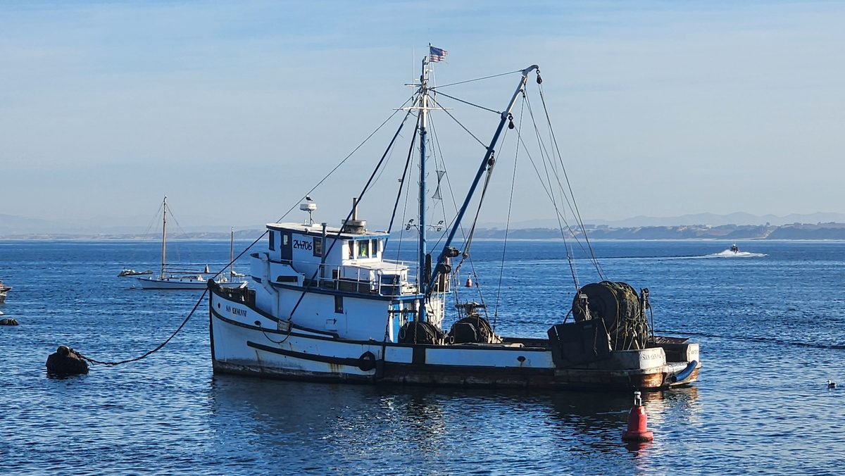 A working fishing boat anchored in a calm blue bay