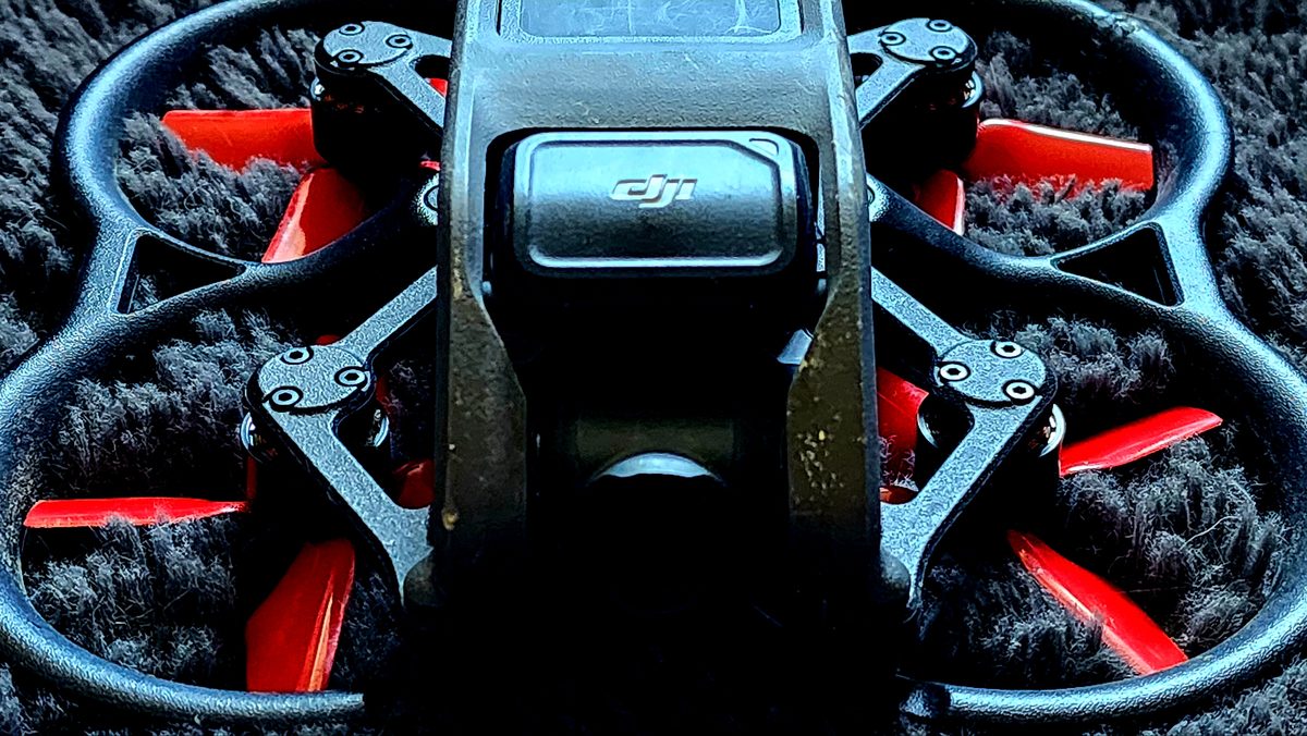 Close-up of a small ducted FPV drone with red propellers