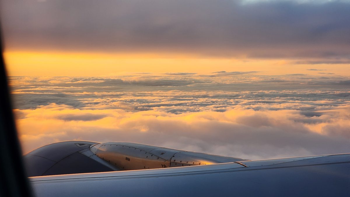 Golden sunset clouds seen through an airplane window