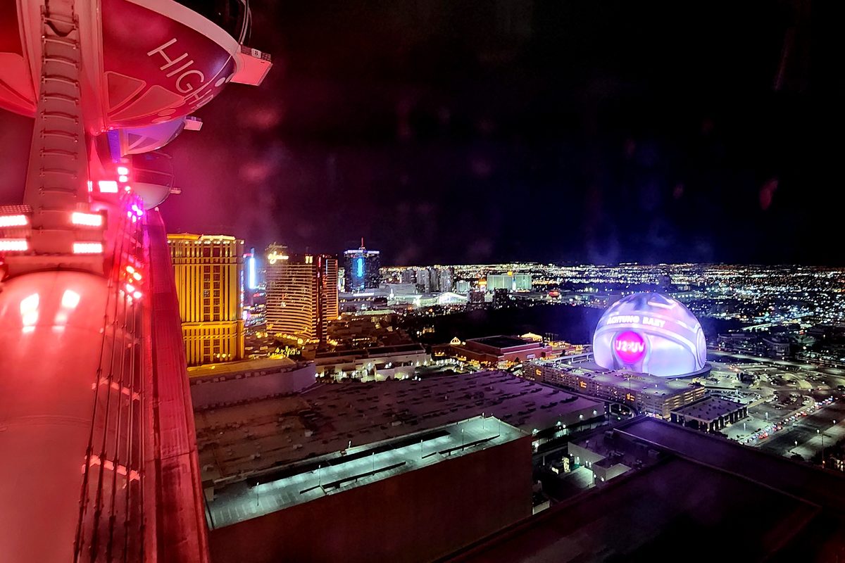 The Las Vegas Sphere glowing in the distance beyond the Strip at night