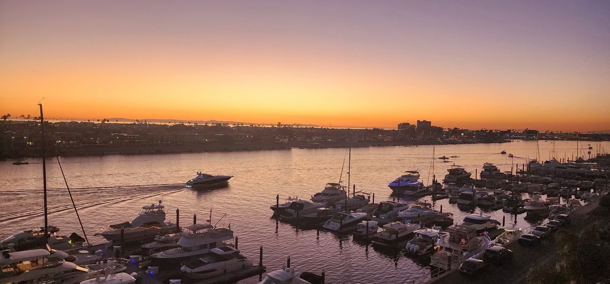 A marina full of boats glowing in the last light of sunset