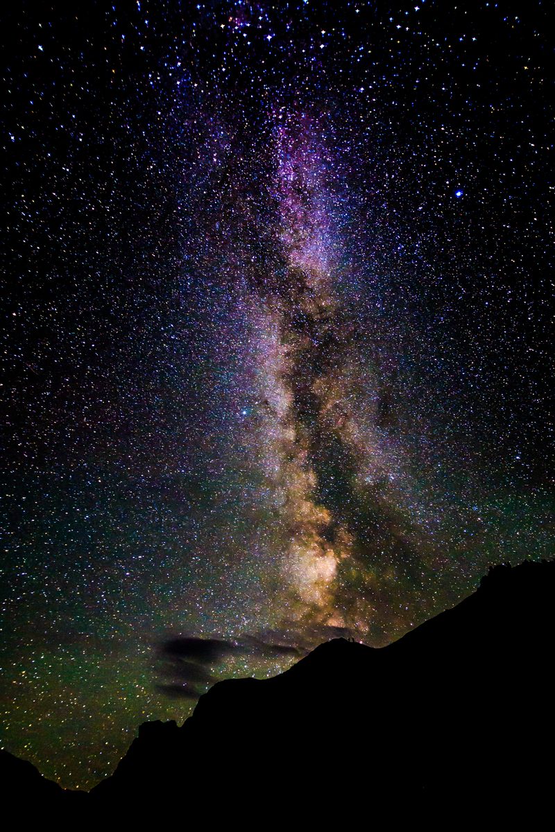 The Milky Way rising above a dark canyon ridge under a star-filled sky