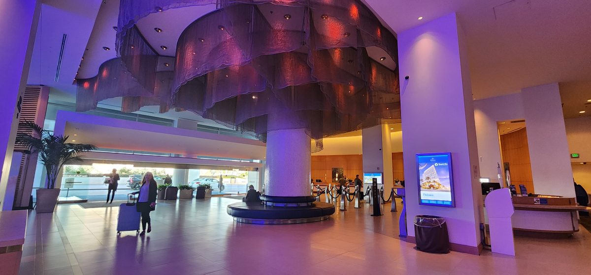 A bright modern airport terminal with purple lighting