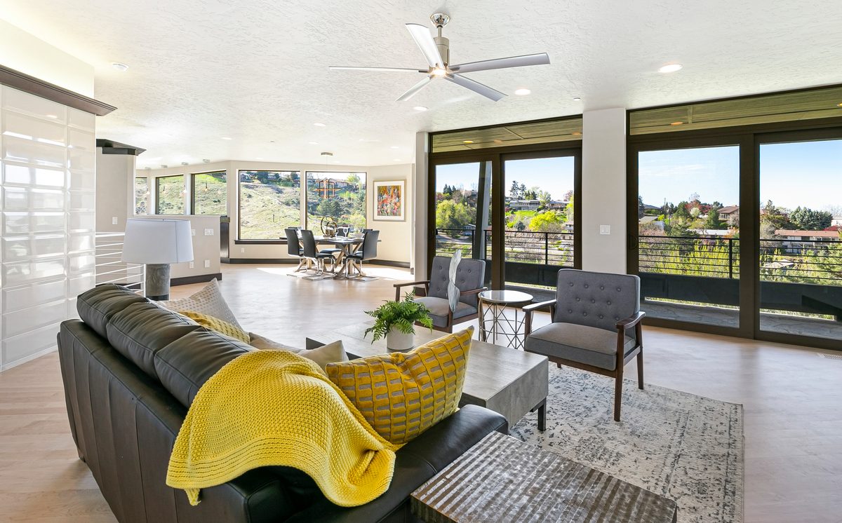 Modern living room with black-framed windows and a sculptural yellow chair