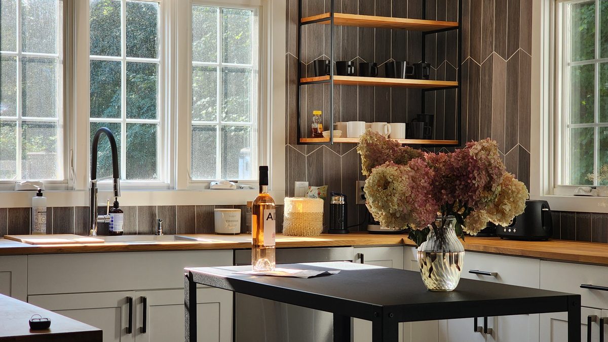 Soft morning light through tall windows onto a kitchen table with flowers