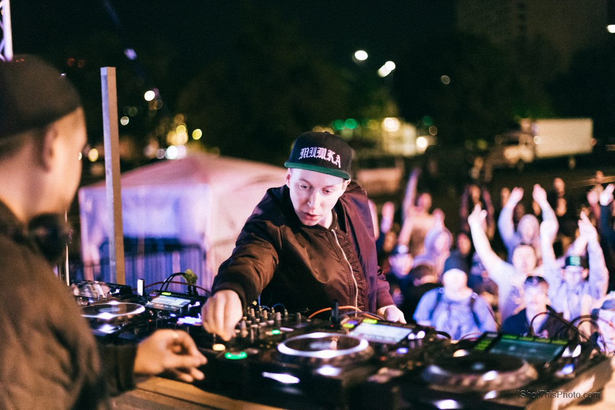 Mt Eden at the decks under festival lights with a cheering crowd behind them at night