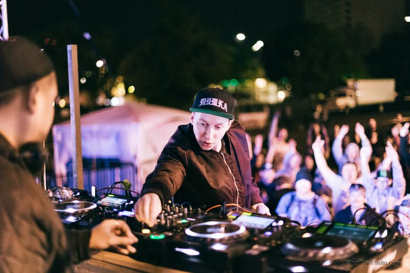 Mt Eden at the decks under festival lights with a cheering crowd behind them at night