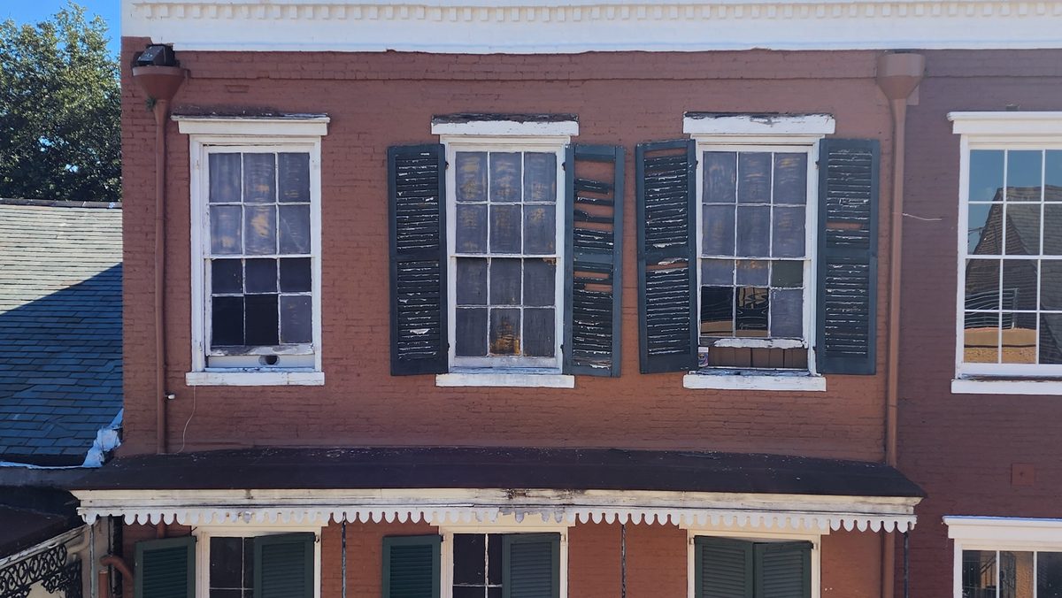 A red-brick building with green shutters in New Orleans