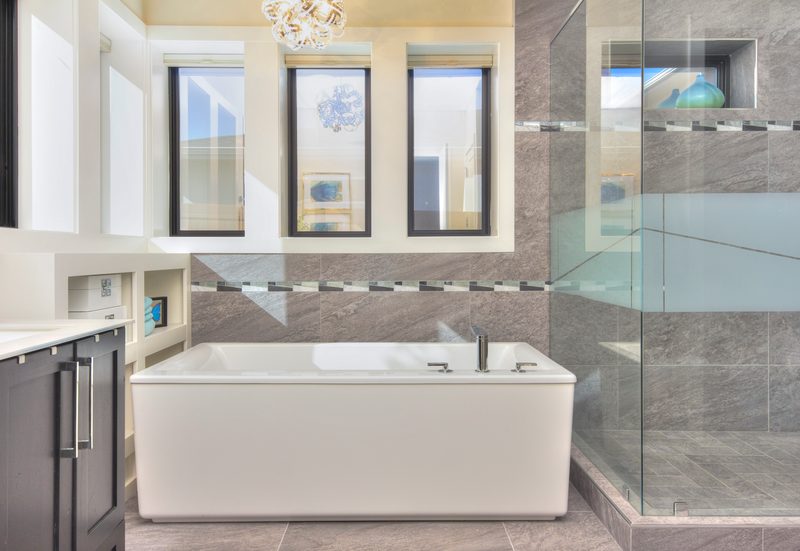 Modern bathroom with a freestanding soaking tub, glass shower and tall windows