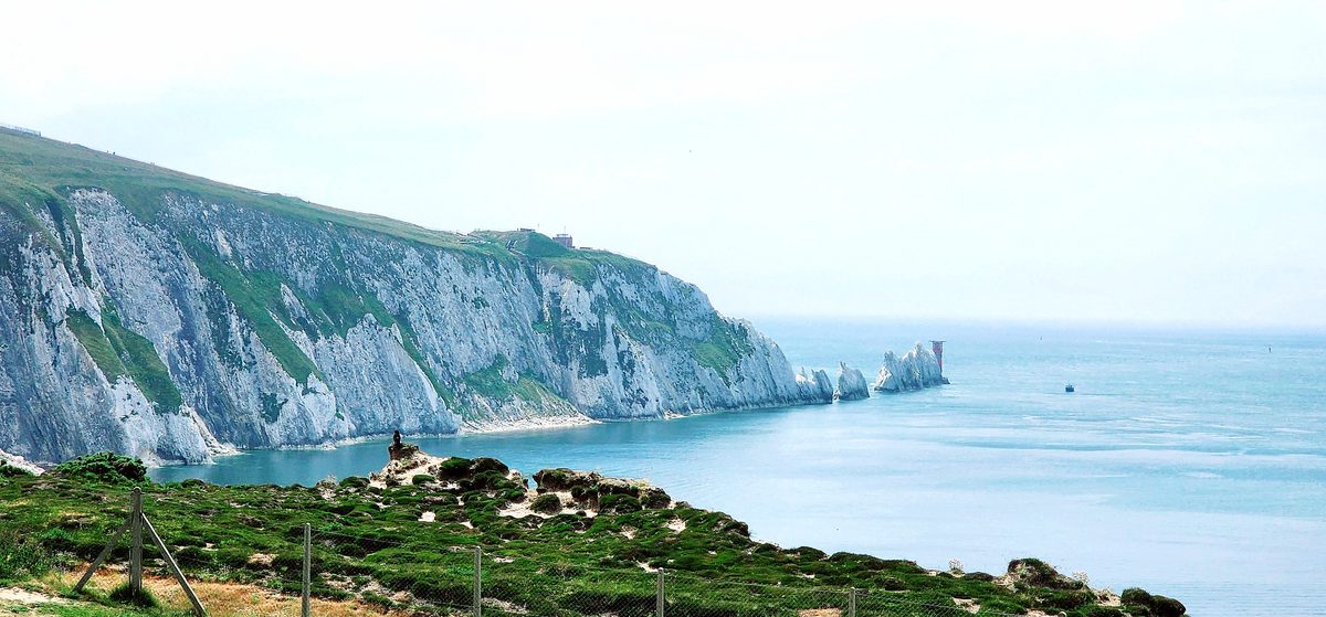 The Needles chalk stacks and lighthouse rising from a calm sea