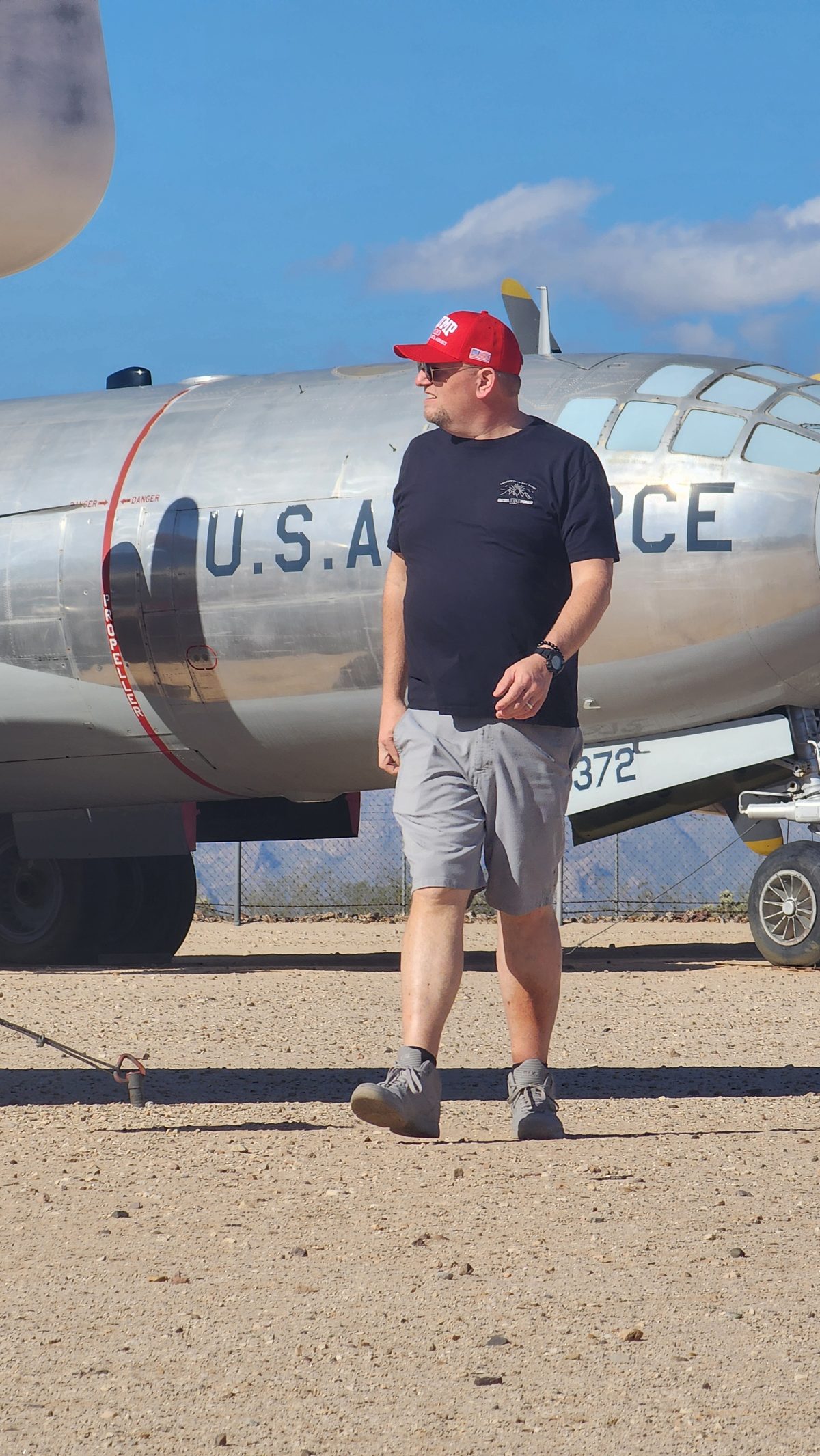 A man in a red cap standing in front of a U.S. Air Force aircraft