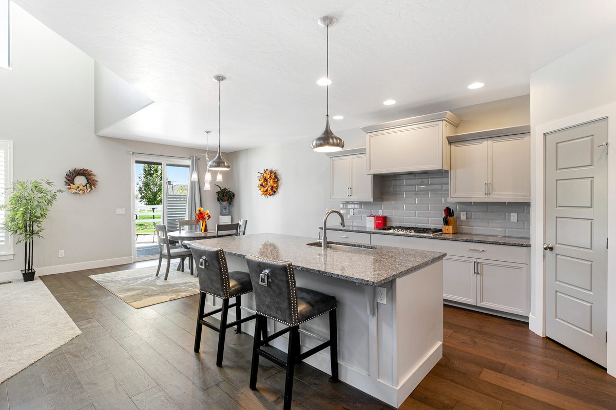 White kitchen with an island and a small dining nook by the windows