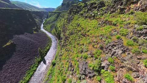 FPV drone dives down a basalt river canyon