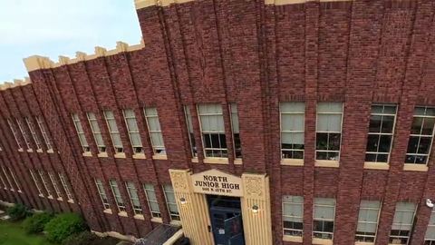 Drone flies over a historic brick building in Boise